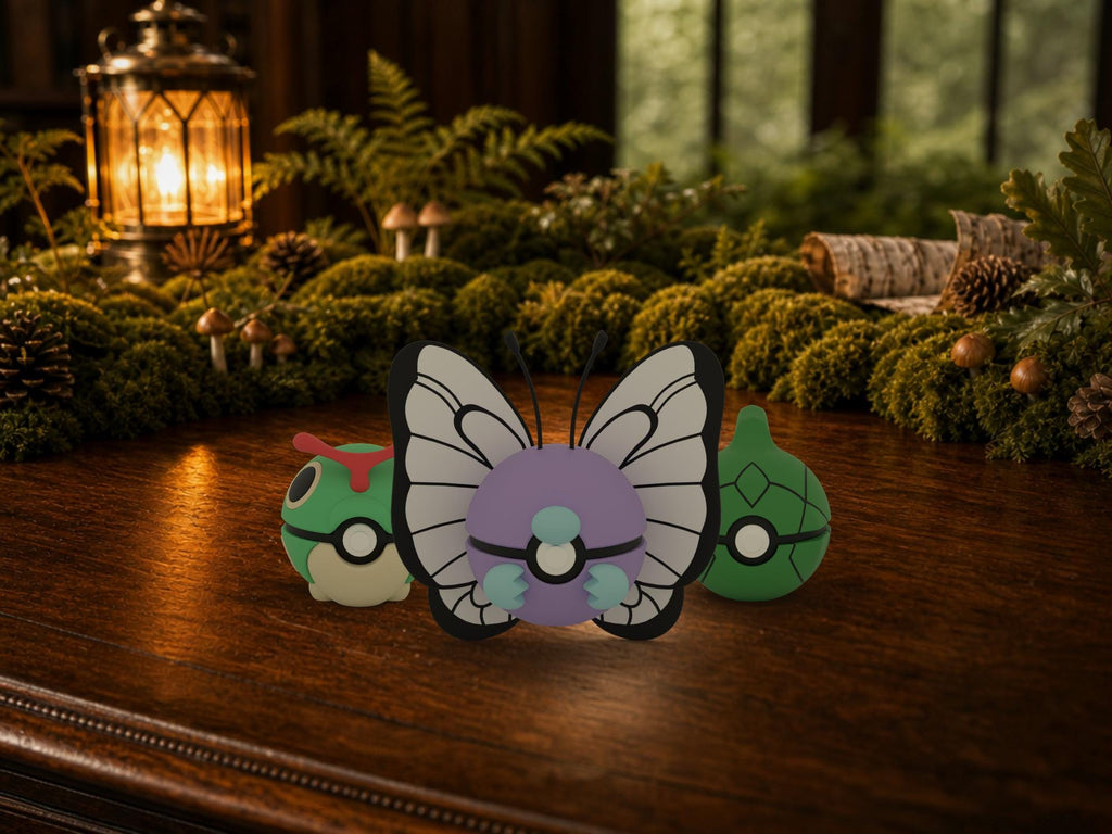 Caterpie, Metapod and Butterfree N3D Poké Balls on a woodland study desk, 3D printed Pokeball clicker evolution line