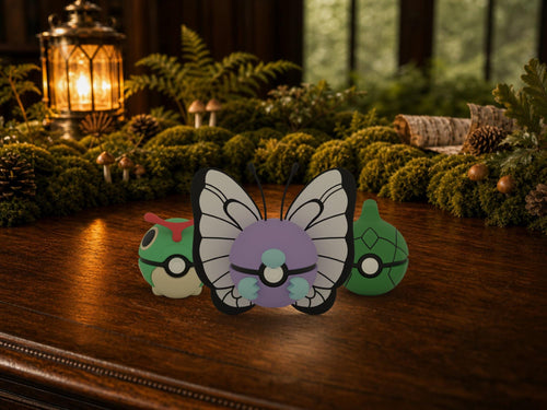 Caterpie, Metapod and Butterfree N3D Poké Balls on a woodland study desk, 3D printed Pokeball clicker evolution line